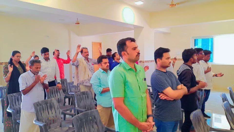 Men of the congregation standing with hands raised in worship